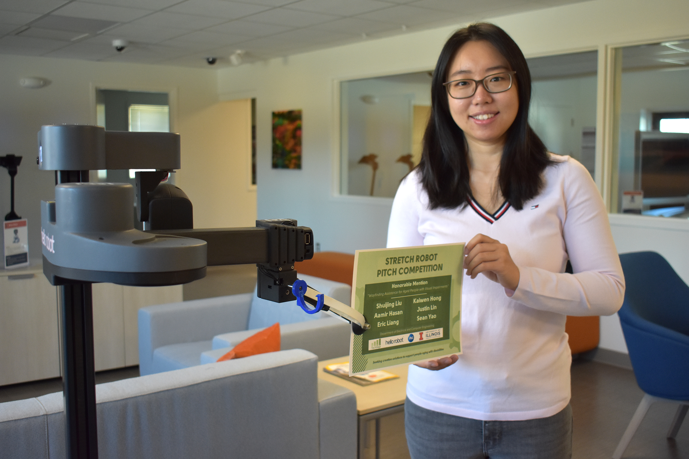 Shuijing Liu poses with Stretch Robot handing her an award certificate